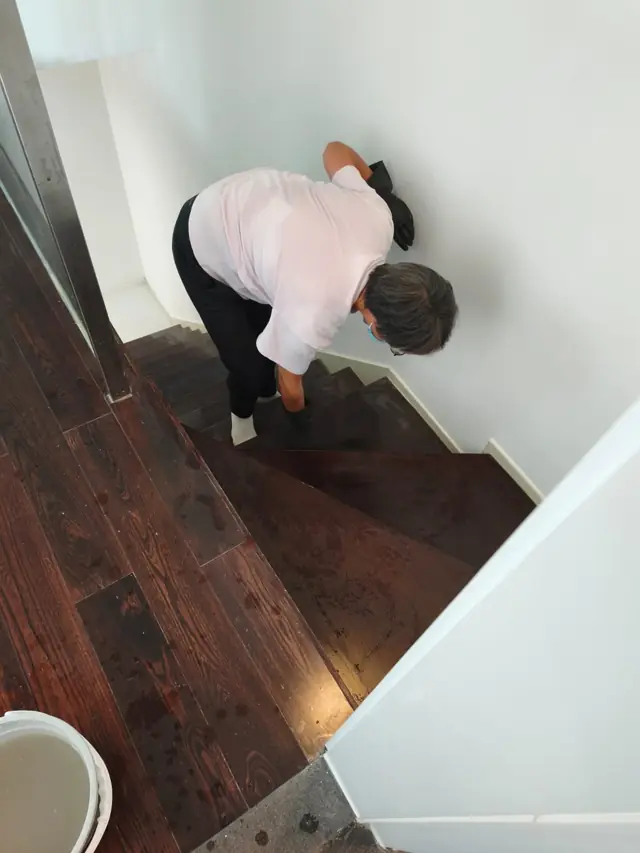 清潔人員為木樓梯逐級抹淨